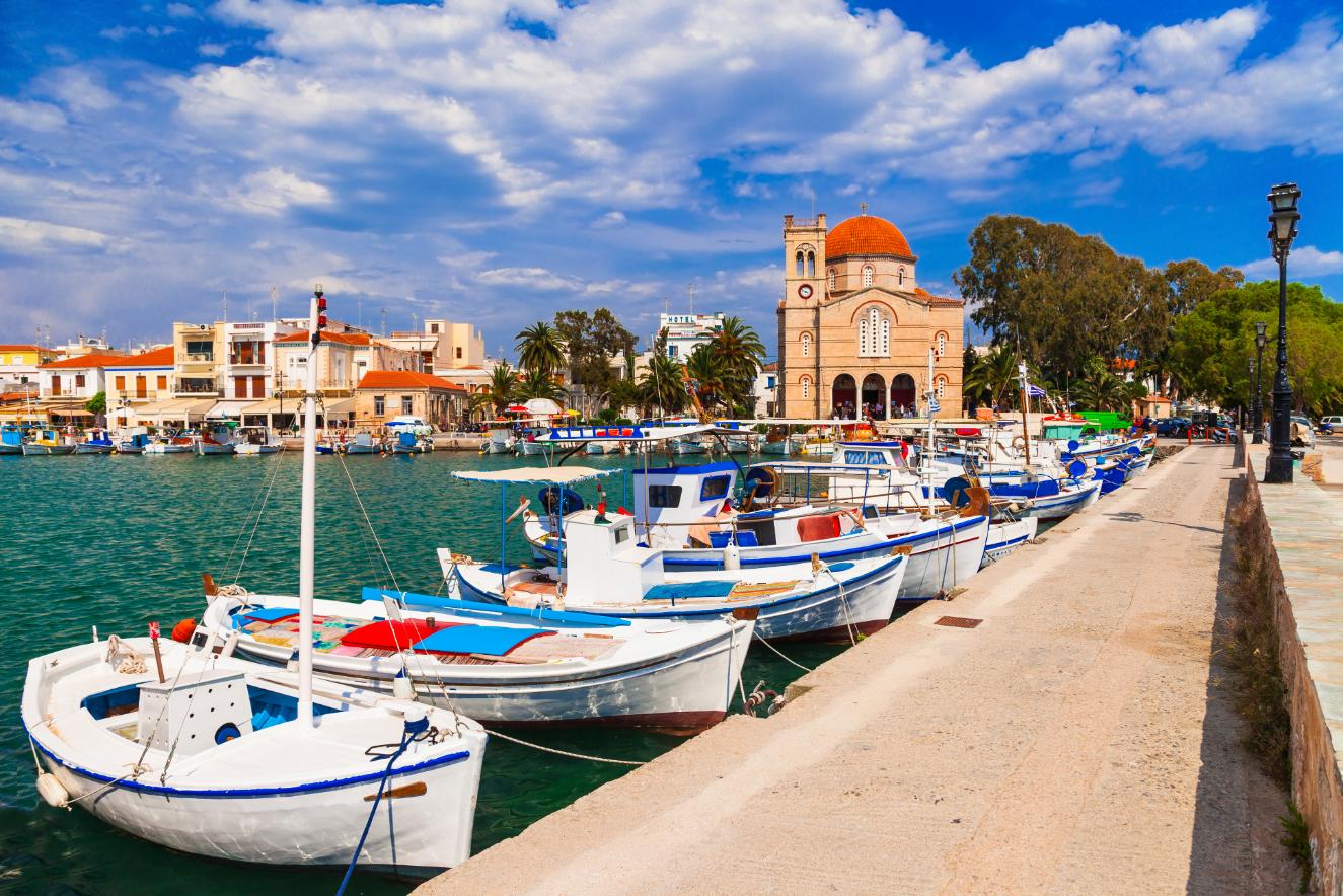 Fishing boats and waterfront church in Aegina harbor, Saronic Gulf, Greece