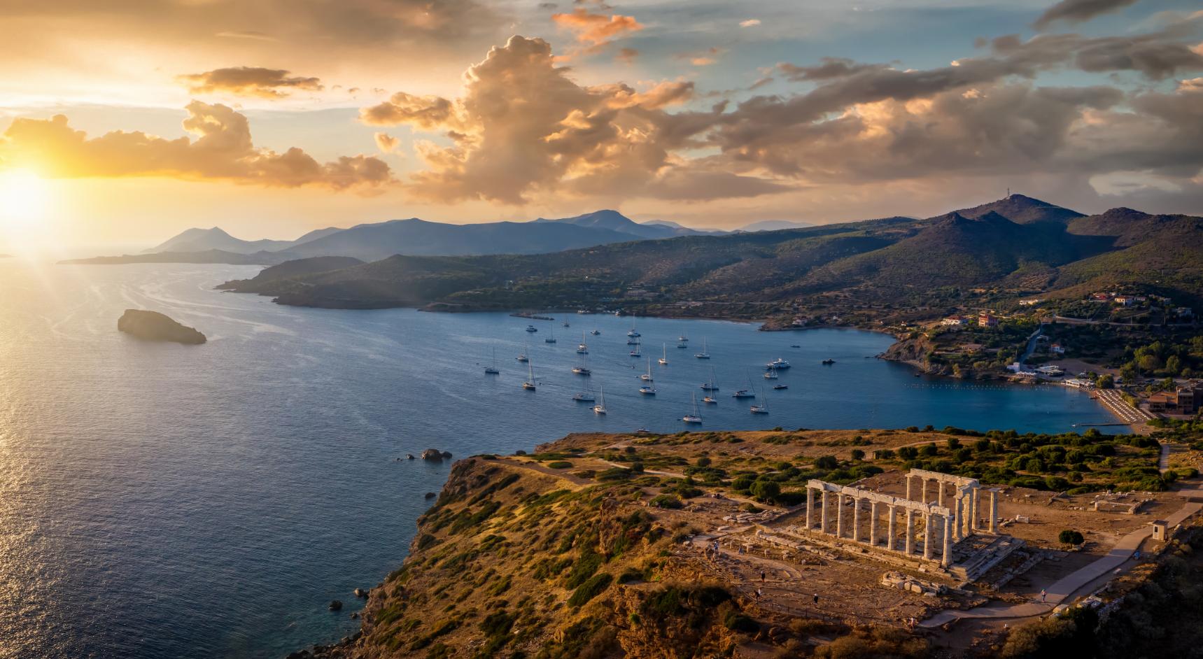 Temple of Poseidon at Cape Sounion overlooking the Aegean Sea at sunset in Greece