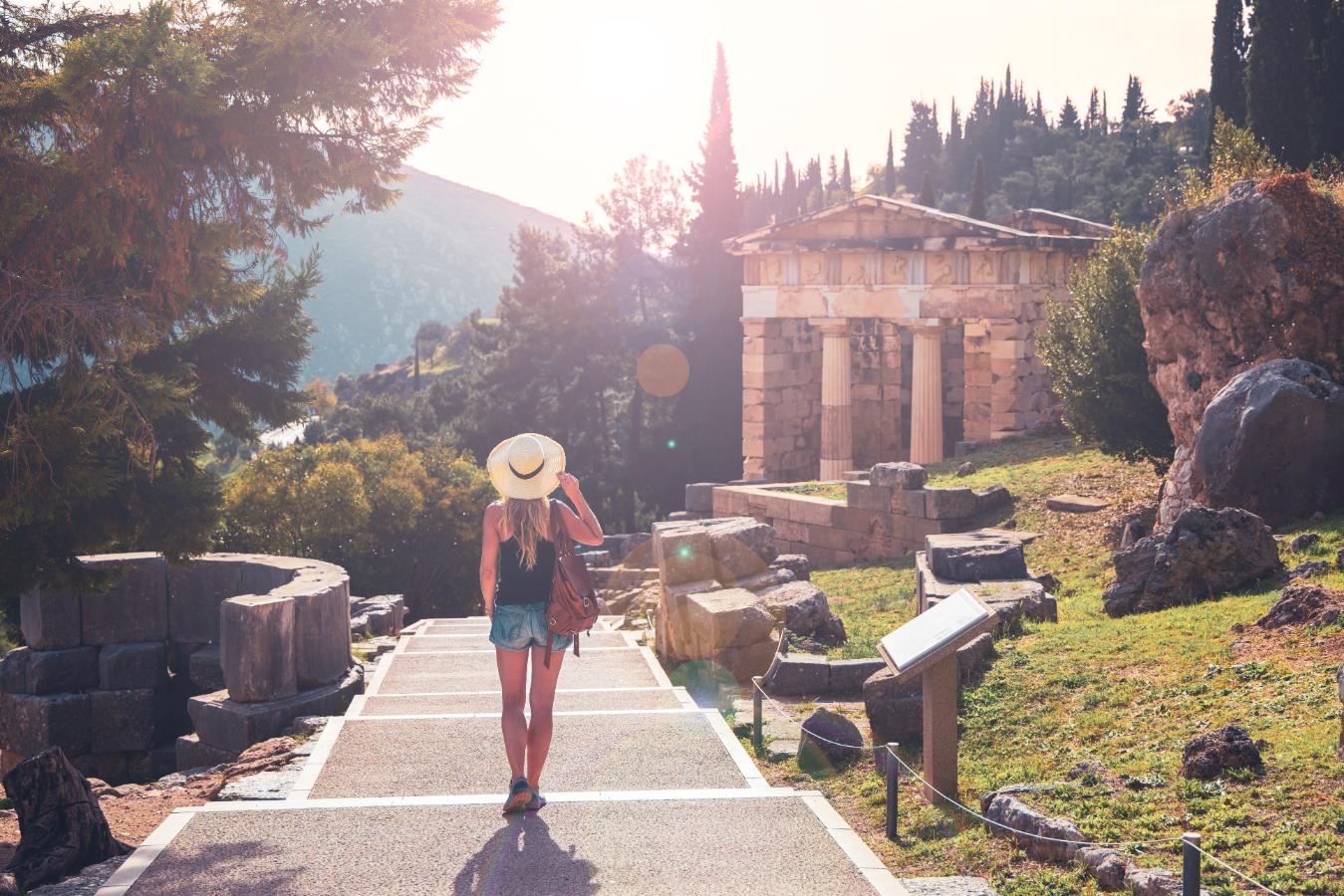 Tourist walking toward the Temple of Athena Pronaia at Delphi archaeological site in Greece