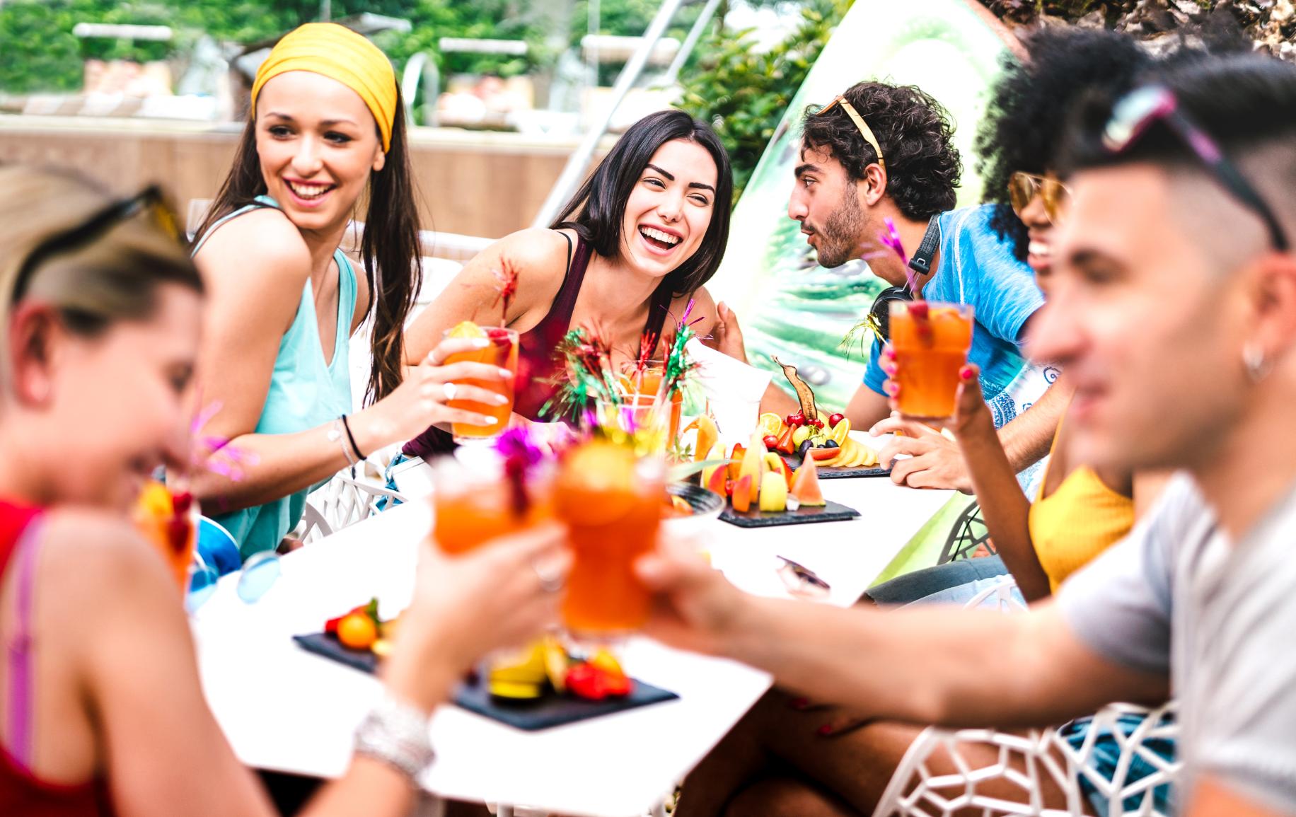 Friends enjoying cocktails and food together during a summer gathering