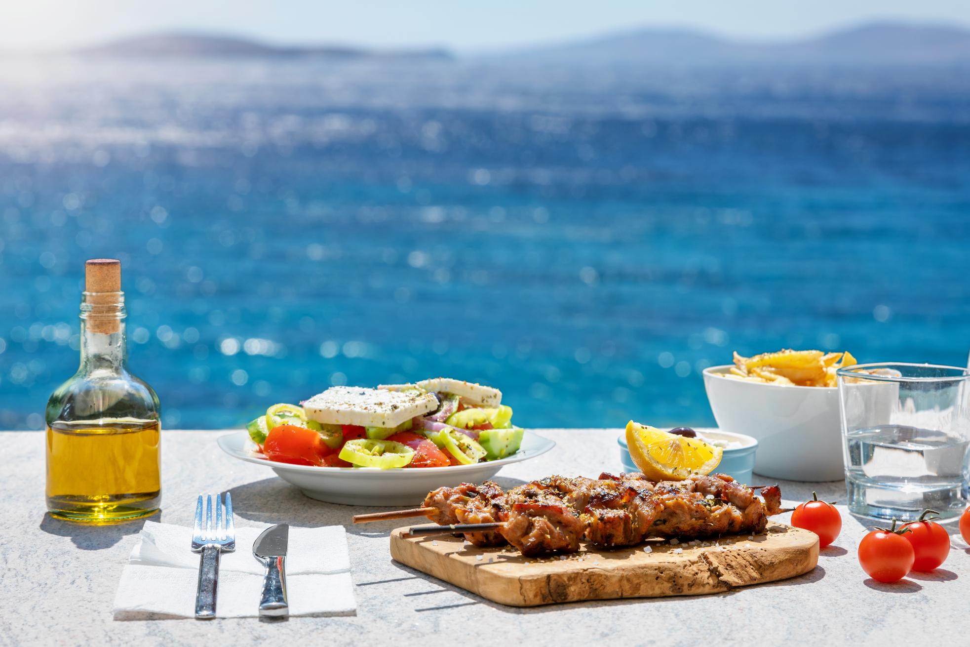 Traditional Greek souvlaki with Greek salad served by the sea