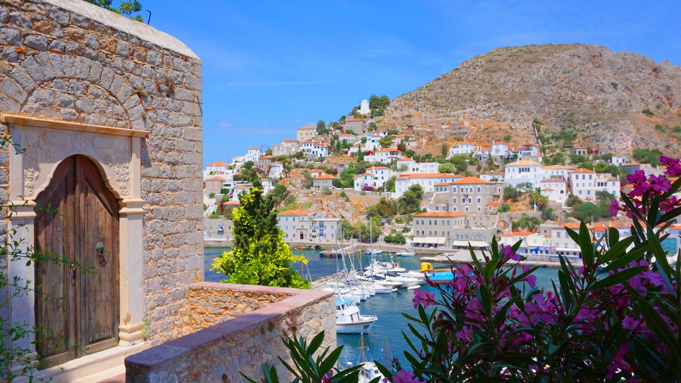 Scenic view of Hydra Island harbor with traditional houses and marina in Greece