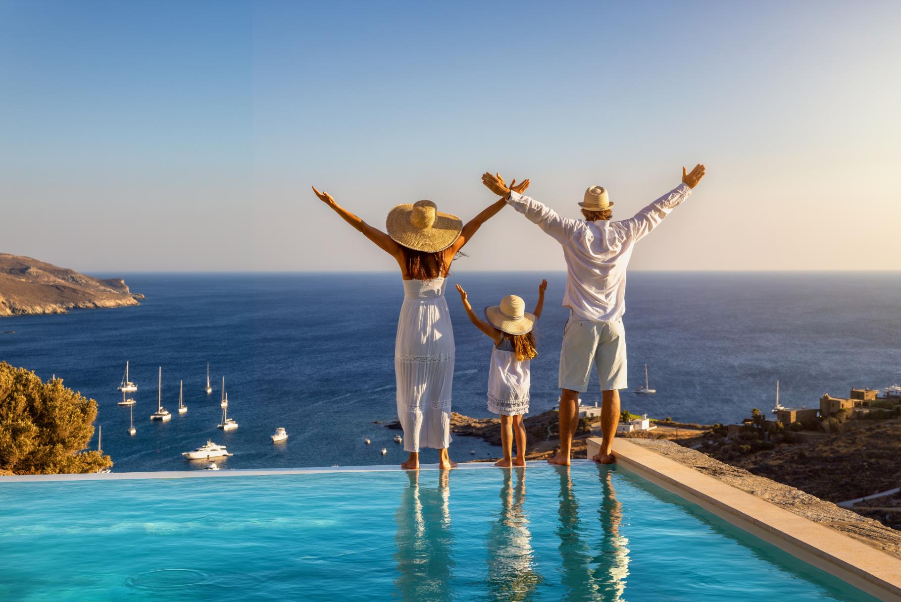 Family enjoying sunset view from infinity pool at luxury Greek island villa