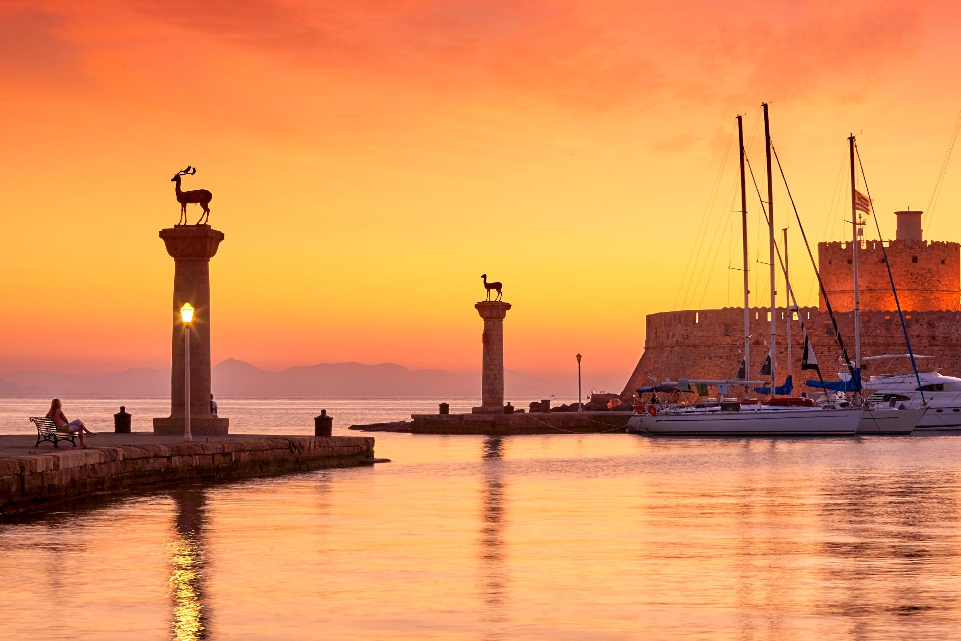 Mandraki Harbor deer statues at sunset in Rhodes Town, Rhodes Island Greece