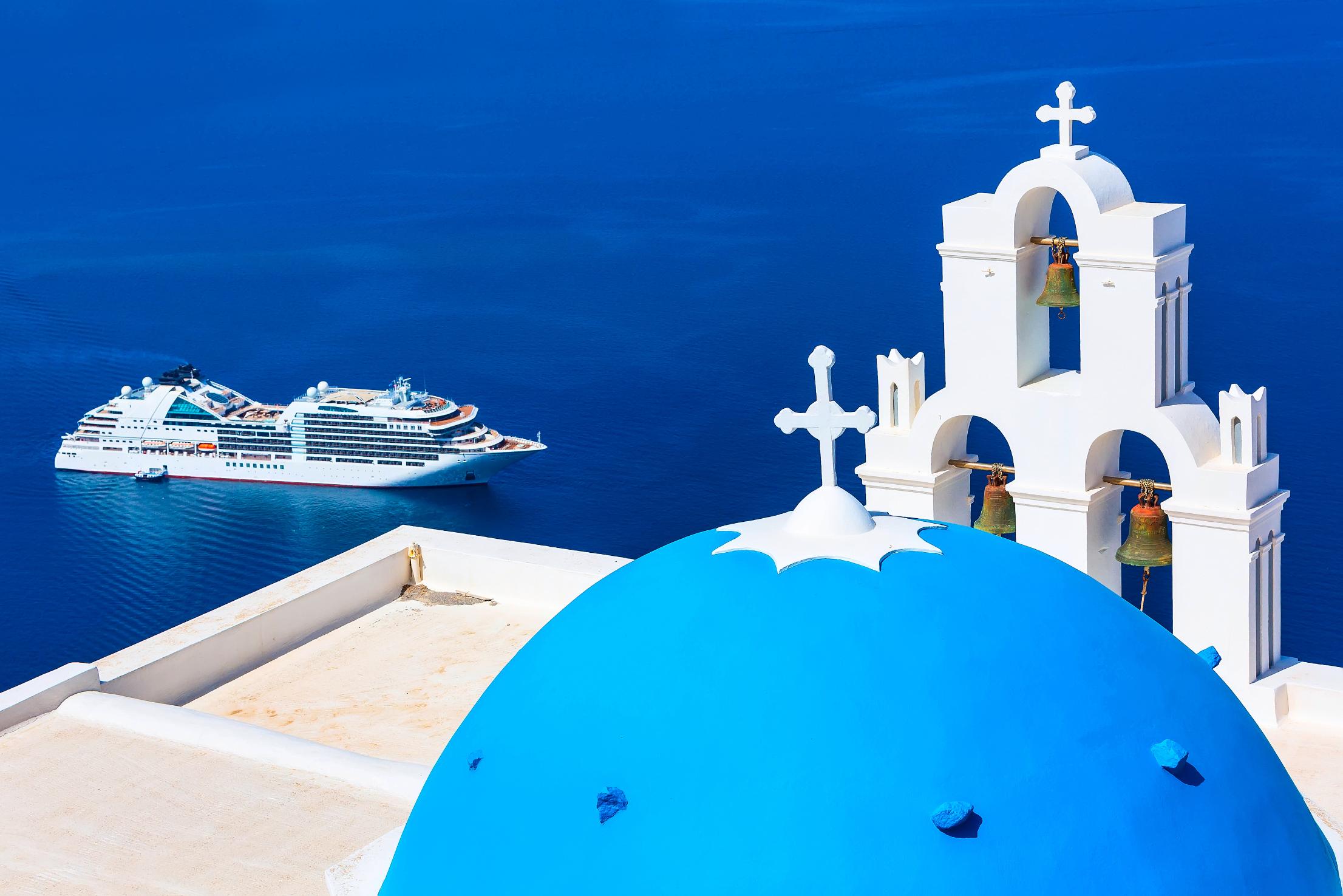 Blue dome church and cruise ship in the Santorini caldera, Cyclades Islands, Greece
